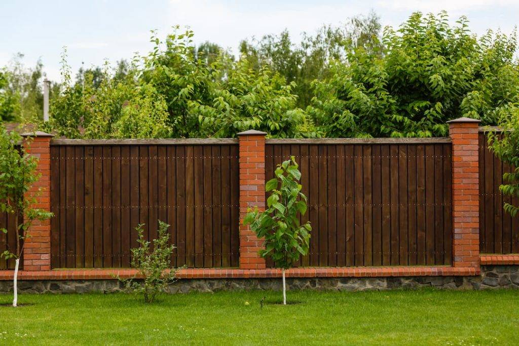 Wooden fence panels between brick uprights